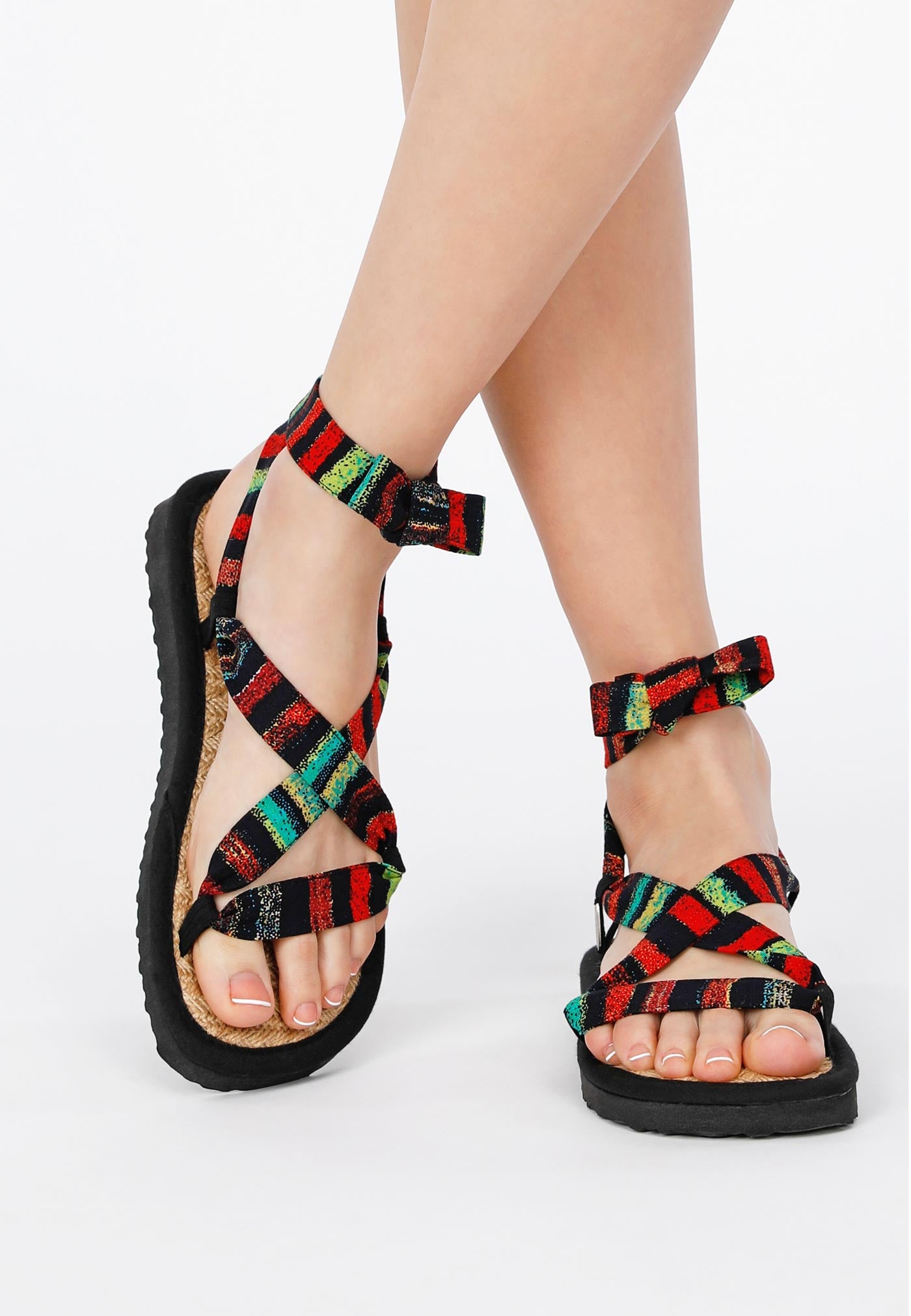 Sandale mit verstellbaren Riemchen aus buntem Stoff, getragen von einem weiblichen Modell