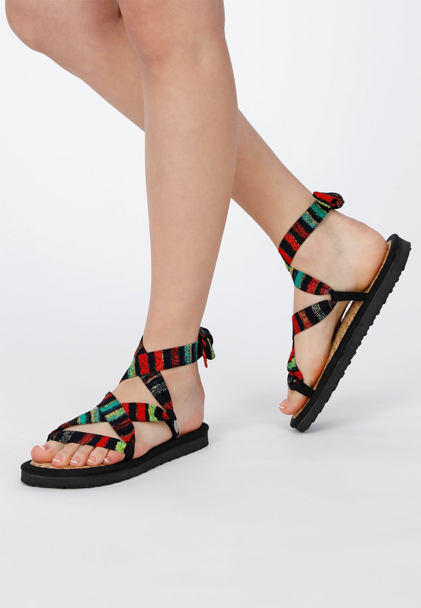 Sandale mit verstellbaren Riemchen aus buntem Stoff, getragen von einem weiblichen Modell, von der Seite