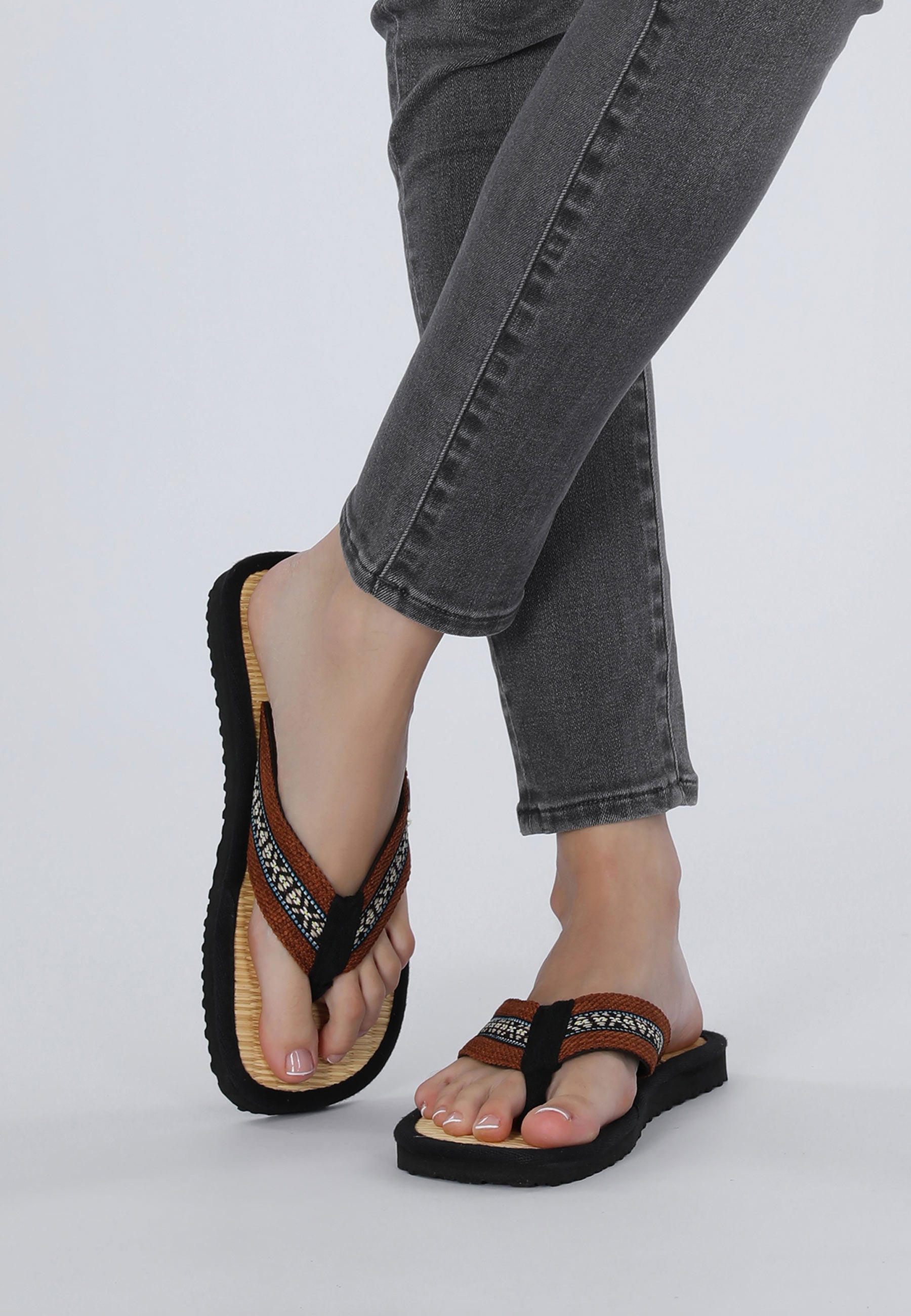 Zehentrenner mit braunen Riemen, von einem weiblichem Modell getragen, von Vorne